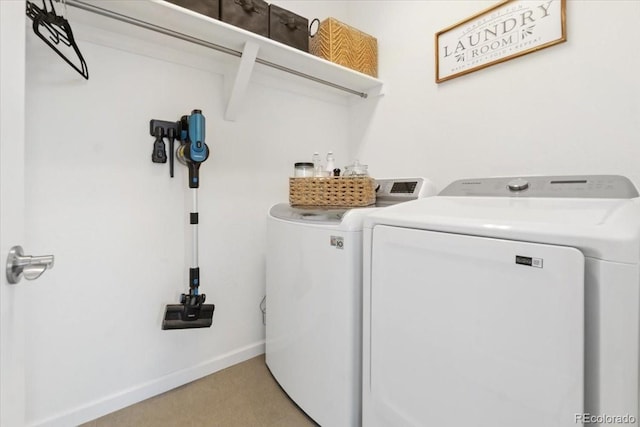 washroom featuring laundry area, baseboards, and washer and dryer