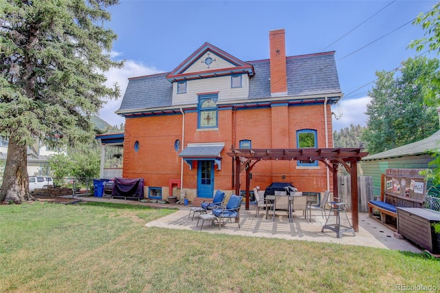 back of property featuring a lawn, a patio area, and a pergola