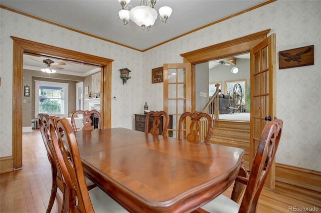 dining room with ceiling fan with notable chandelier, light hardwood / wood-style floors, ornamental molding, and french doors