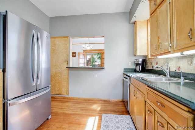 kitchen with an inviting chandelier, sink, decorative backsplash, light hardwood / wood-style floors, and stainless steel appliances