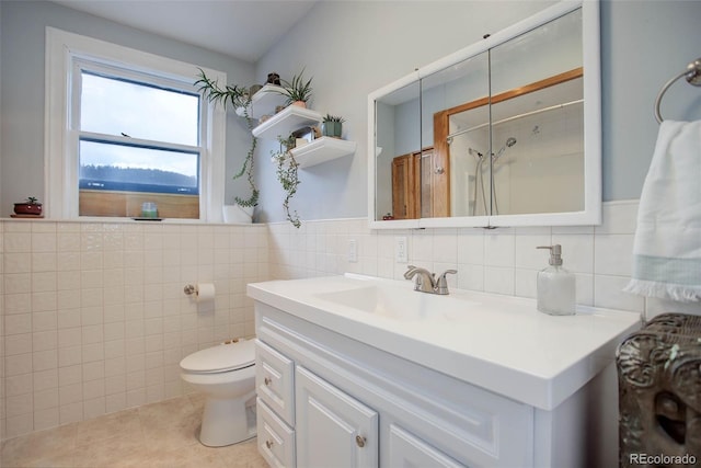 bathroom featuring vanity, tile patterned flooring, toilet, walk in shower, and tile walls