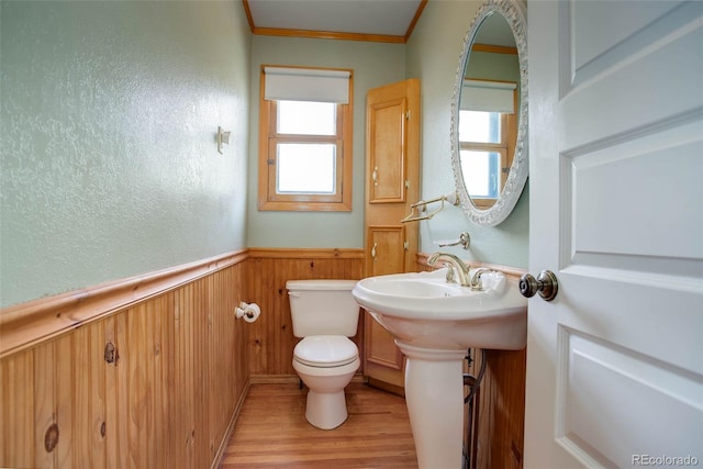 bathroom featuring hardwood / wood-style flooring, toilet, a wealth of natural light, and crown molding