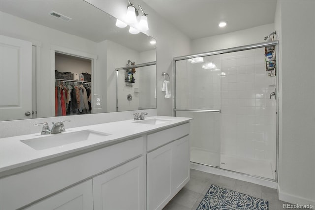 9 N Waterloo St, Aurora, CO 80018 - full bathroom featuring a stall shower, double vanity, a walk in closet, and tile patterned floors
