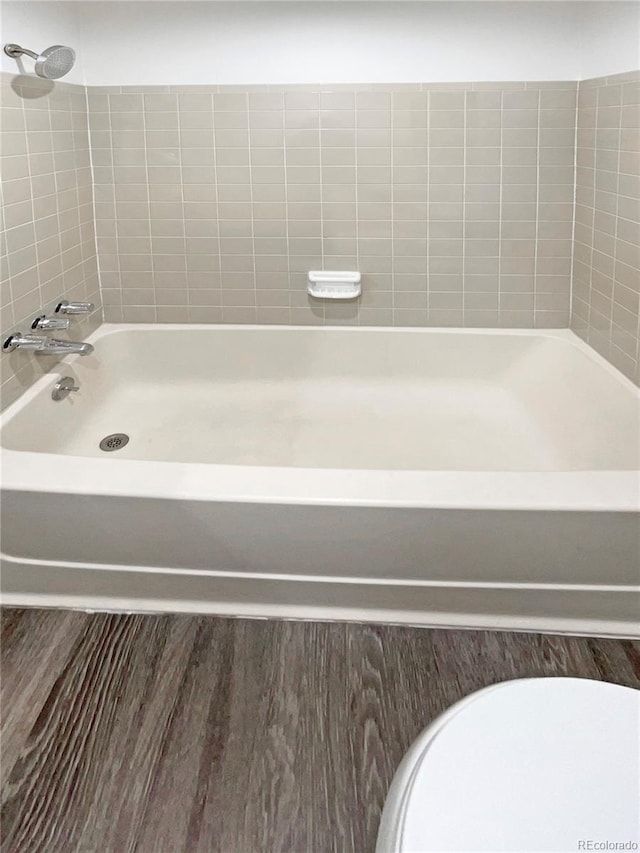 bathroom with toilet and washtub / shower combination