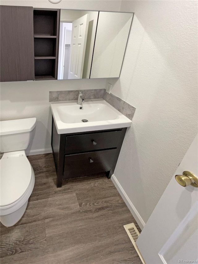 bathroom featuring hardwood / wood-style floors, vanity, and toilet