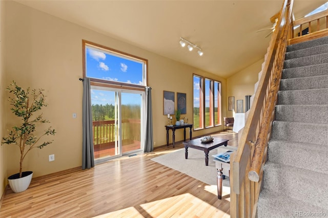 428 Ridge Dr, Divide, CO 80814 - living area featuring stairway, wood finished floors, plenty of natural light, rail lighting, and high vaulted ceiling