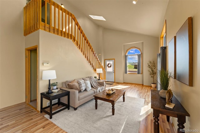 428 Ridge Dr, Divide, CO 80814 - living room with stairway, light wood finished floors, high vaulted ceiling, and a skylight