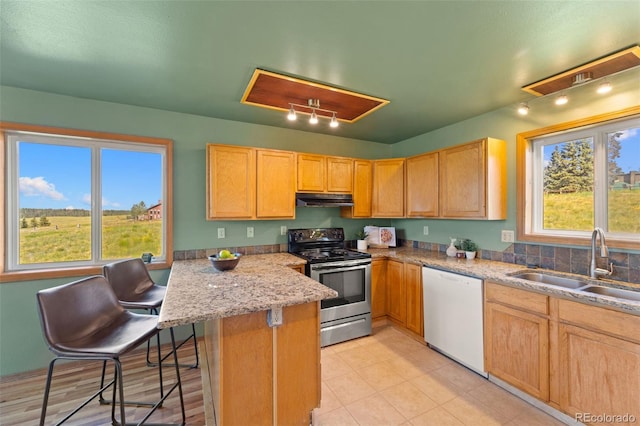 428 Ridge Dr, Divide, CO 80814 - kitchen with electric range, white dishwasher, a peninsula, a breakfast bar area, and light brown cabinetry