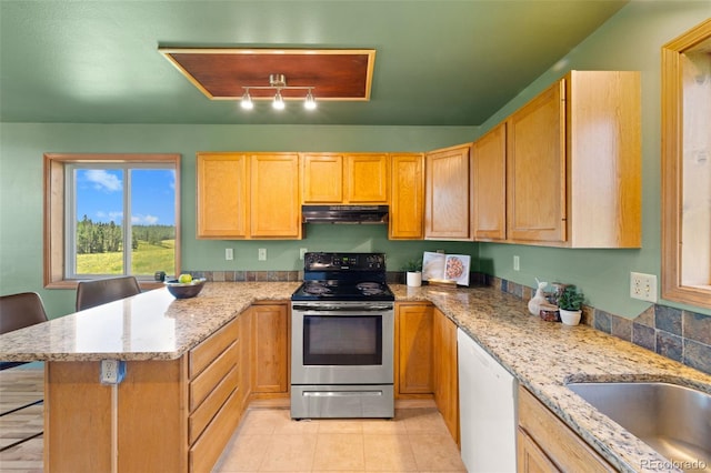 428 Ridge Dr, Divide, CO 80814 - kitchen with stainless steel electric range, a peninsula, dishwasher, under cabinet range hood, and light stone countertops