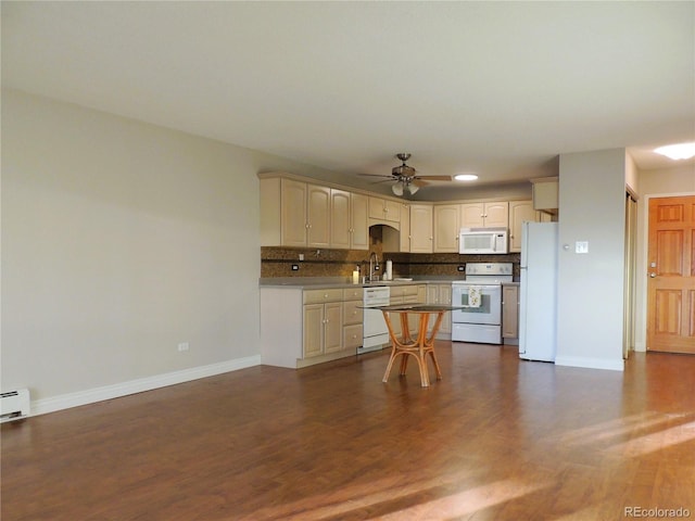 kitchen with white appliances, a sink, baseboards, dark wood-style floors, and tasteful backsplash