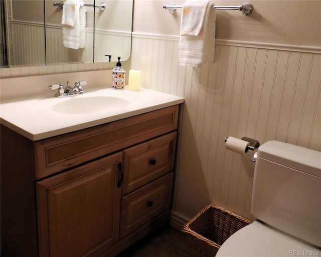 bathroom featuring wainscoting, vanity, and toilet