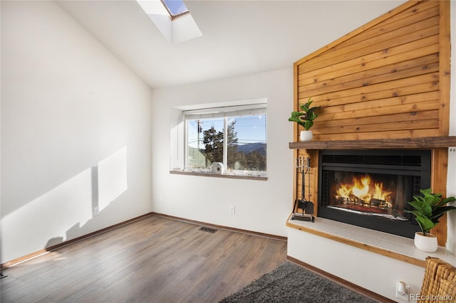 unfurnished living room featuring hardwood / wood-style flooring and lofted ceiling with skylight