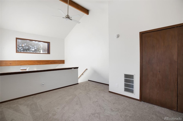 carpeted empty room with visible vents, baseboards, ceiling fan, beam ceiling, and high vaulted ceiling