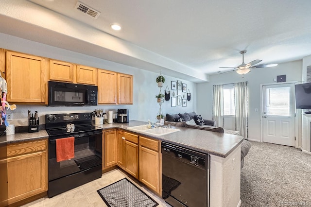 kitchen featuring visible vents, open floor plan, a sink, a peninsula, and black appliances