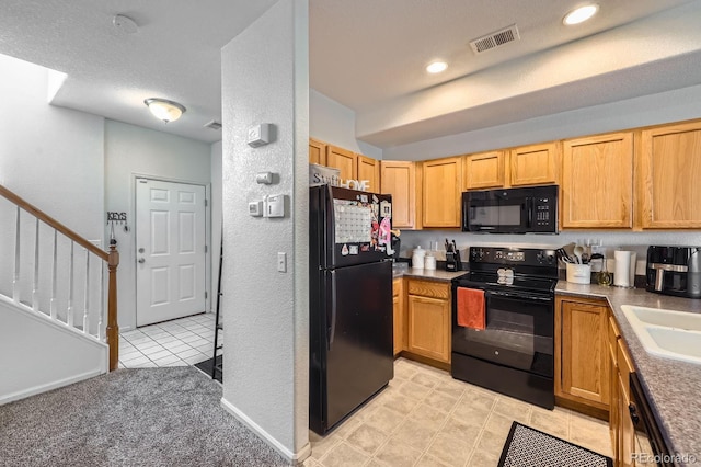 kitchen with recessed lighting, visible vents, a sink, black appliances, and baseboards