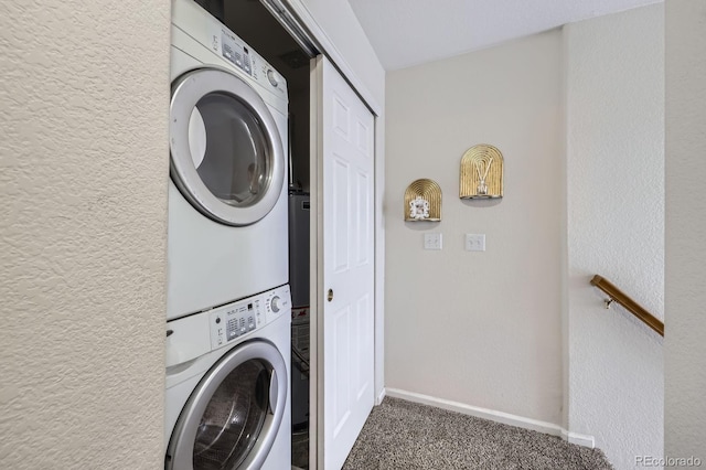 laundry room featuring a textured wall, laundry area, baseboards, carpet, and stacked washer and clothes dryer