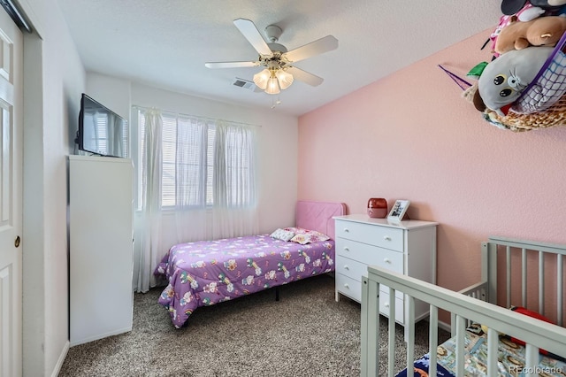 carpeted bedroom with visible vents and a ceiling fan