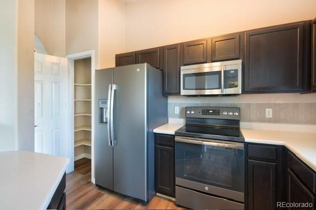 3864 Riviera Grv Unit 204, Colorado Springs, CO 80922 - kitchen featuring a high ceiling, dark brown cabinetry, light wood-type flooring, light countertops, and appliances with stainless steel finishes