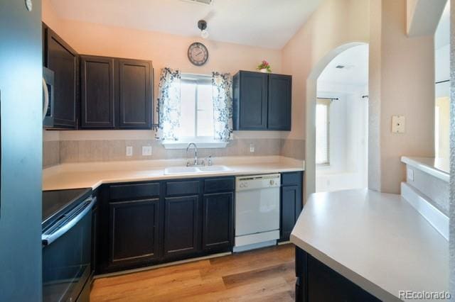 3864 Riviera Grv Unit 204, Colorado Springs, CO 80922 - kitchen featuring a sink, arched walkways, black electric range oven, light countertops, and white dishwasher