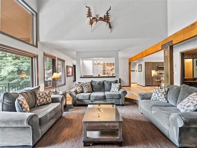 living room with a notable chandelier, a high ceiling, and wood finished floors