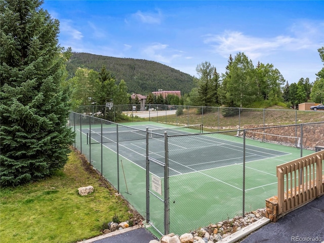 view of sport court with fence and a mountain view