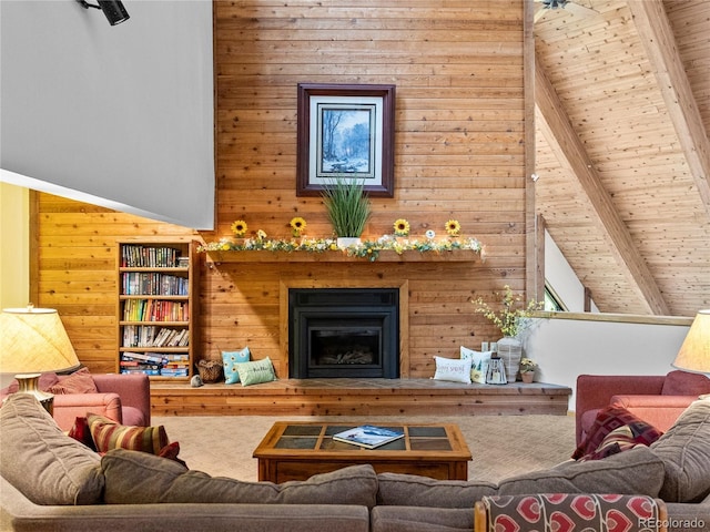 living room with wooden walls, wood ceiling, a fireplace, and beamed ceiling