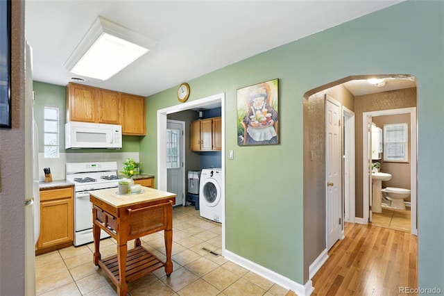 2461 Niagara St, Denver, CO 80207 - kitchen featuring white appliances, washer / dryer, arched walkways, and plenty of natural light
