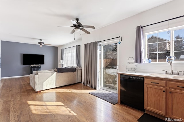 interior space featuring sink, ceiling fan, black dishwasher, and light hardwood / wood-style flooring