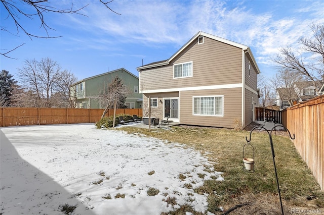 view of snow covered rear of property