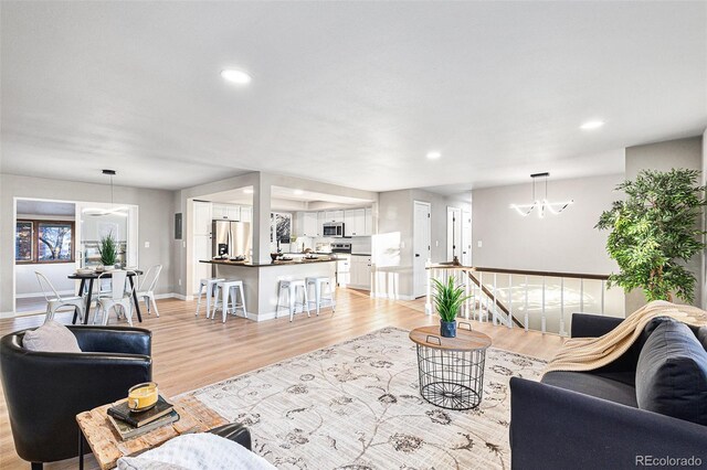 living room featuring a chandelier and light wood-type flooring