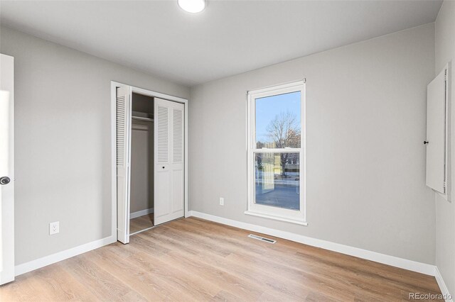 unfurnished bedroom featuring a closet and light hardwood / wood-style flooring