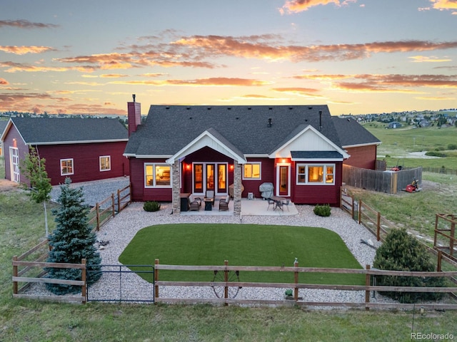 3124 Antelope Ridge Trl, Parker, CO 80138 - back of house at dusk with a patio, a shingled roof, a fenced backyard, and a chimney
