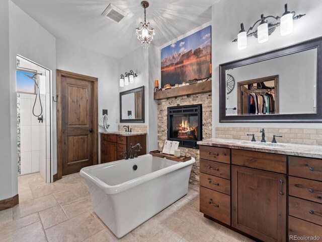 3124 Antelope Ridge Trl, Parker, CO 80138 - full bathroom featuring a soaking tub, a stone fireplace, vanity, and a chandelier