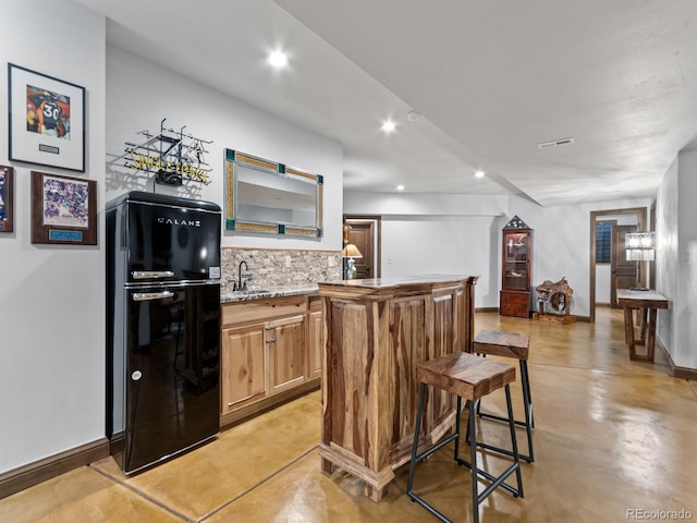 3124 Antelope Ridge Trl, Parker, CO 80138 - kitchen featuring freestanding refrigerator, tasteful backsplash, finished concrete flooring, recessed lighting, and light stone countertops