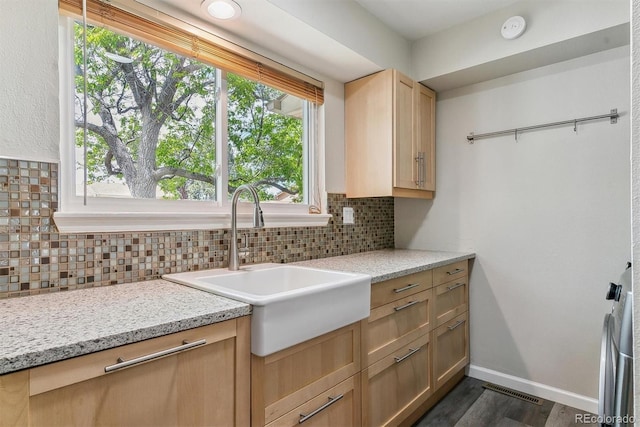 kitchen with decorative backsplash, dark wood-style floors, baseboards, and light brown cabinetry