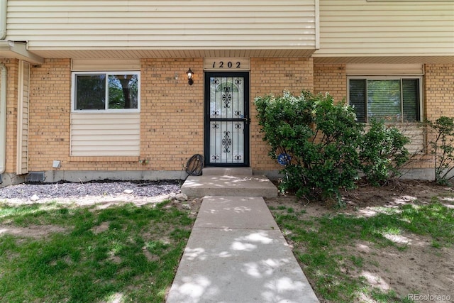 entrance to property with brick siding and covered porch