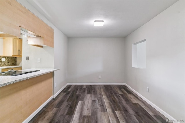 unfurnished dining area featuring dark wood finished floors and baseboards