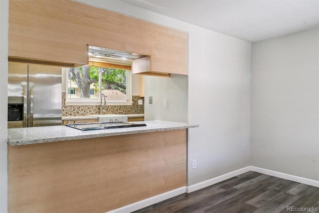 kitchen with stainless steel fridge with ice dispenser, a sink, dark wood-style floors, light stone countertops, and tasteful backsplash
