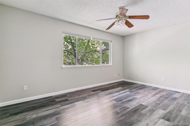 empty room featuring ceiling fan, a textured ceiling, dark wood-type flooring, and baseboards