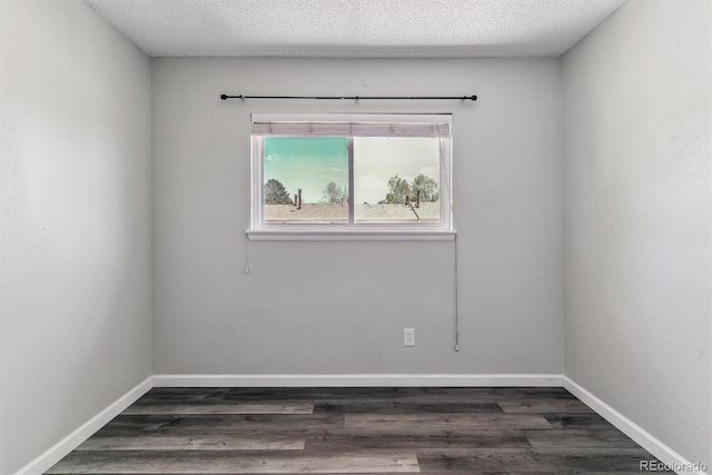 unfurnished room with dark wood finished floors, baseboards, and a textured ceiling