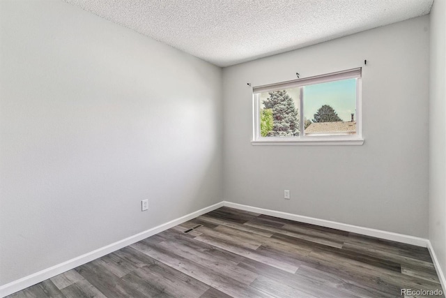 unfurnished room with dark wood-style floors, baseboards, and a textured ceiling