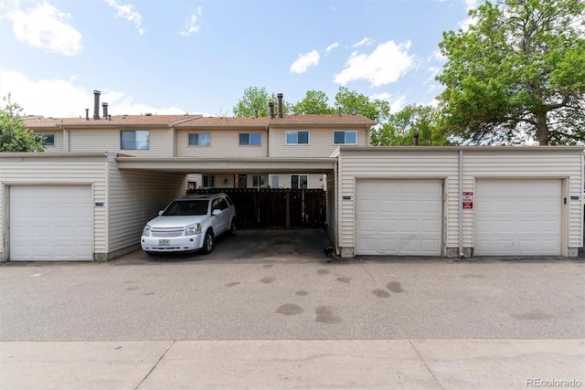 view of property with fence and community garages