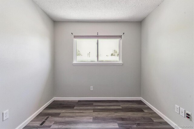 1202 S Troy St, Aurora, CO 80012 - empty room featuring a textured ceiling and dark wood-style floors