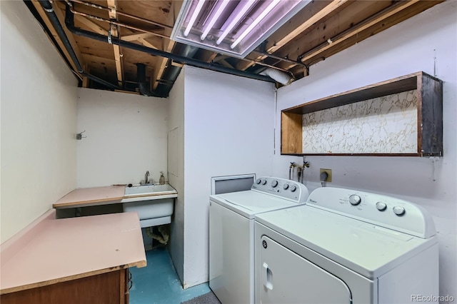 clothes washing area with separate washer and dryer and sink