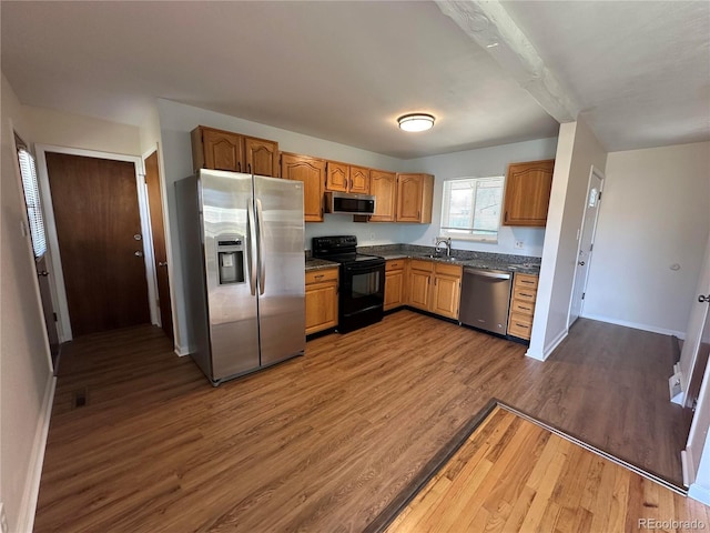11623 E Virginia Dr, Aurora, CO 80012 - kitchen with dark countertops, a sink, stainless steel appliances, baseboards, and dark wood-type flooring