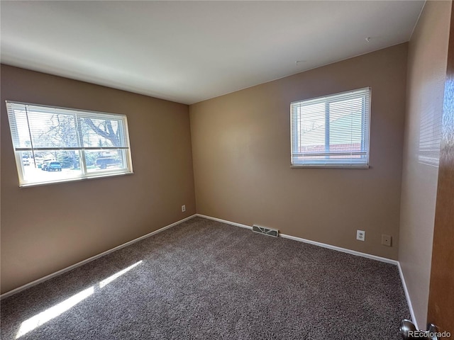 11623 E Virginia Dr, Aurora, CO 80012 - carpeted spare room with baseboards, visible vents, and a wealth of natural light