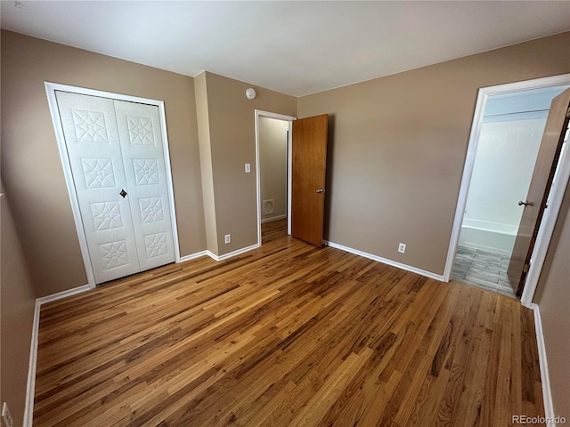 11623 E Virginia Dr, Aurora, CO 80012 - unfurnished bedroom with wood finished floors, a closet, baseboards, and ensuite bathroom