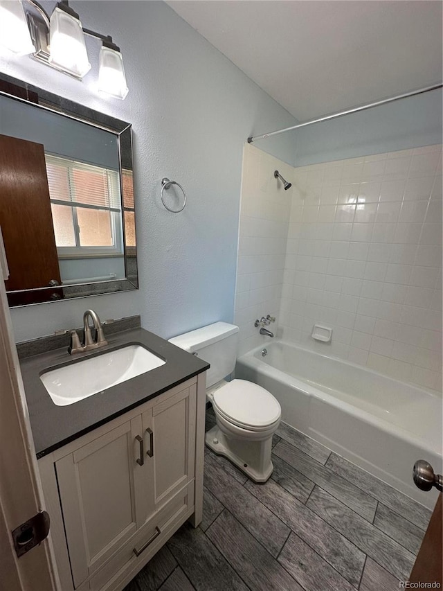 11623 E Virginia Dr, Aurora, CO 80012 - bathroom featuring shower / bathing tub combination, wood finish floors, toilet, and vanity