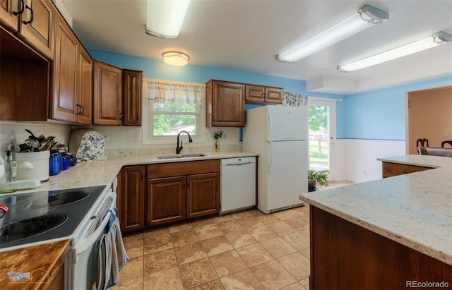 1813 Pikes Peak St, Erie, CO 80516 - kitchen with white appliances, healthy amount of natural light, a wainscoted wall, and light stone counters