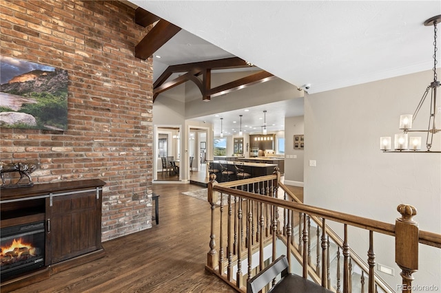 hall featuring dark hardwood / wood-style floors, lofted ceiling with beams, and a chandelier